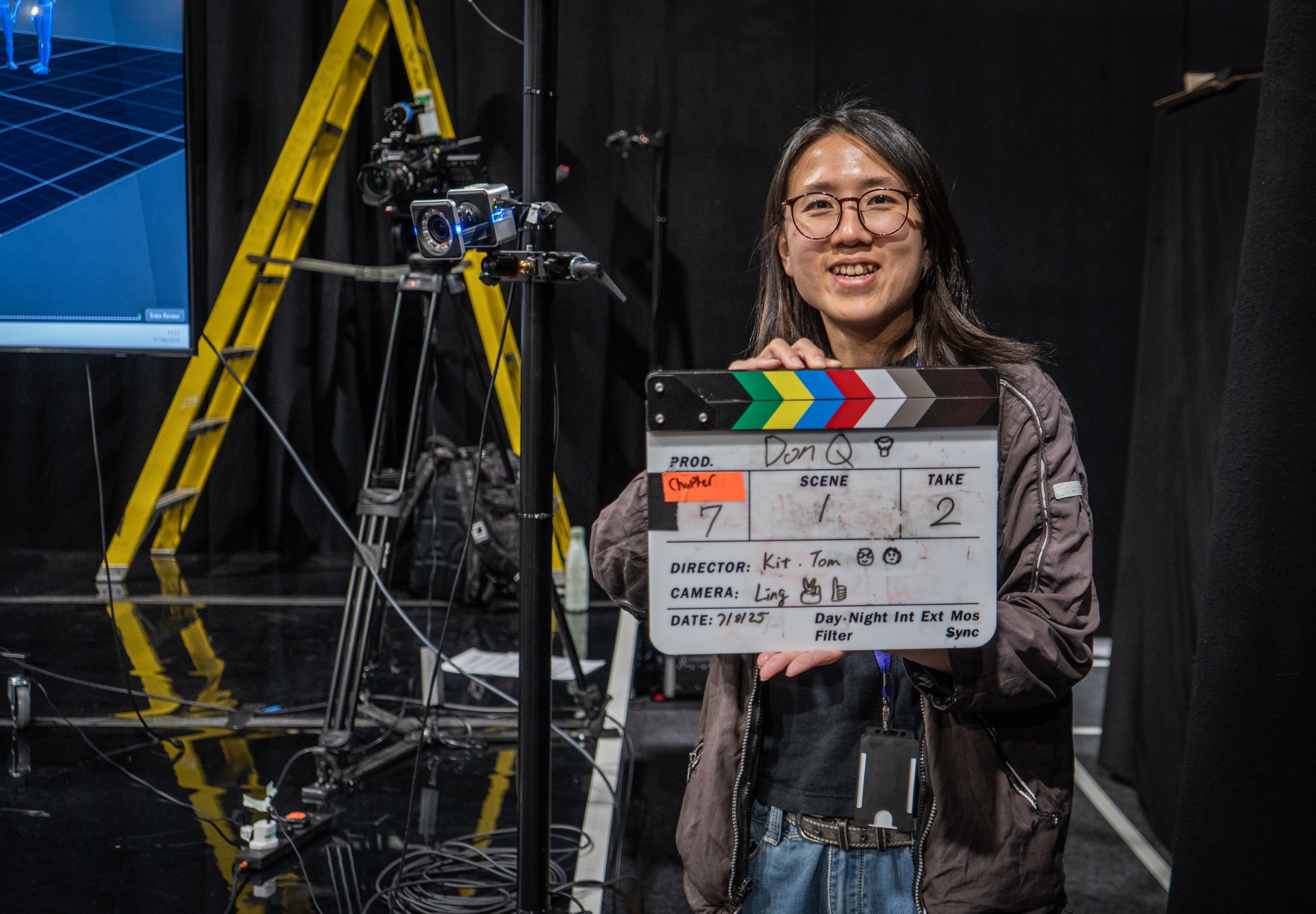 A film artist holding a clapper board on set